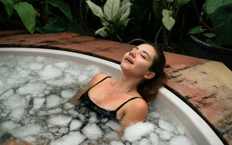 Woman in cold therapy tub relaxing, regulating nervous system for anxiety relief.