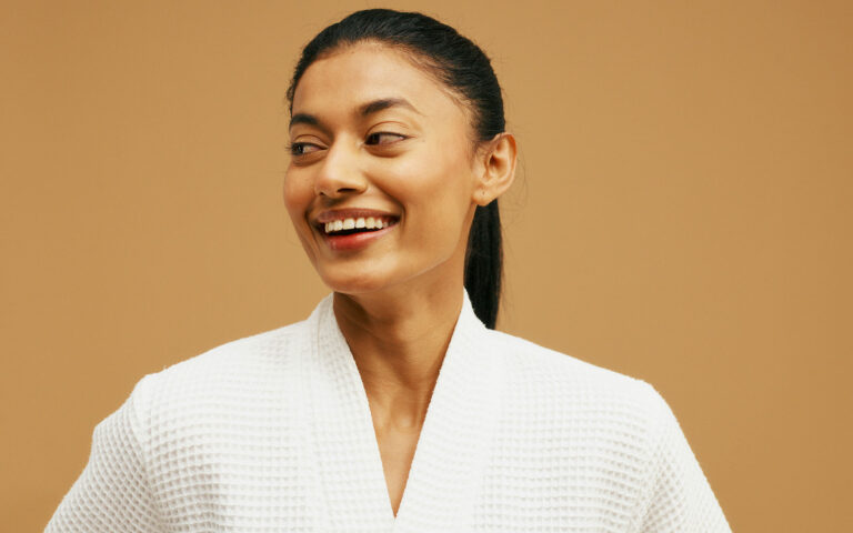 Woman smiling, thyroid health optimization and personalized treatment solutions.