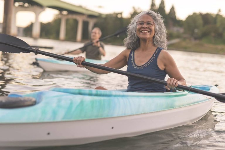 Woman kayaking and enjoying physical activity for hormone balance in midlife.