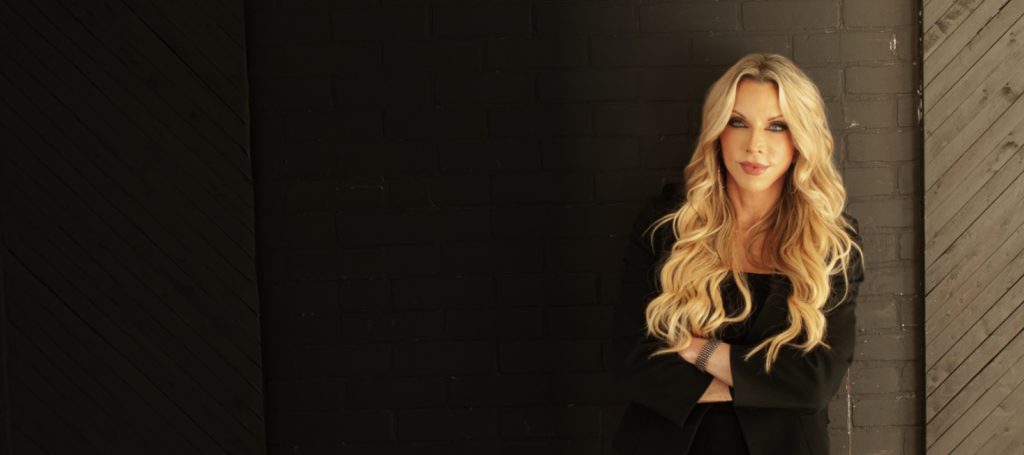 Dr. Amie Hornaman standing against a dark brick wall